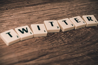 Twitter spelled with Scrabble tiles on wooden background