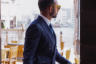 Stylish Businessman in Blue Suit and Sunglasses Walking Outdoors