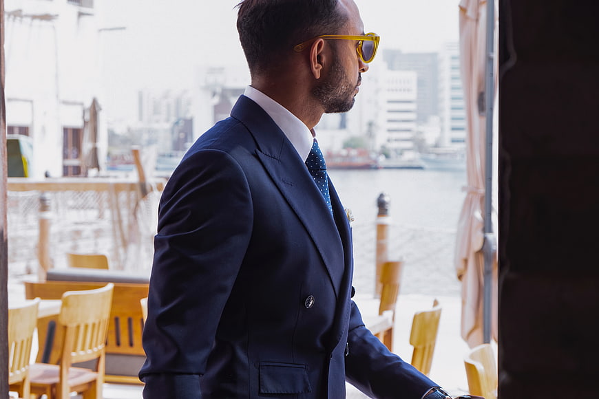 Stylish Businessman in Blue Suit and Sunglasses Walking Outdoors