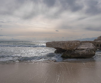 Dramatic coastal landscape with large rock formation and ocean waves
