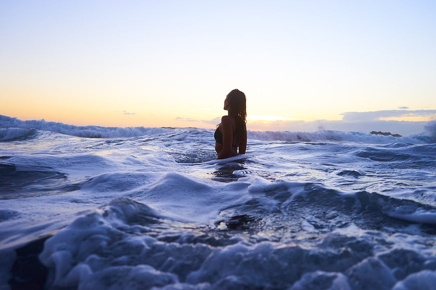 Woman in Ocean Waves at Sunset