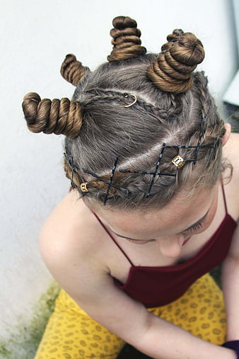 High angle view of woman with intricate braided hair buns and gold accessories