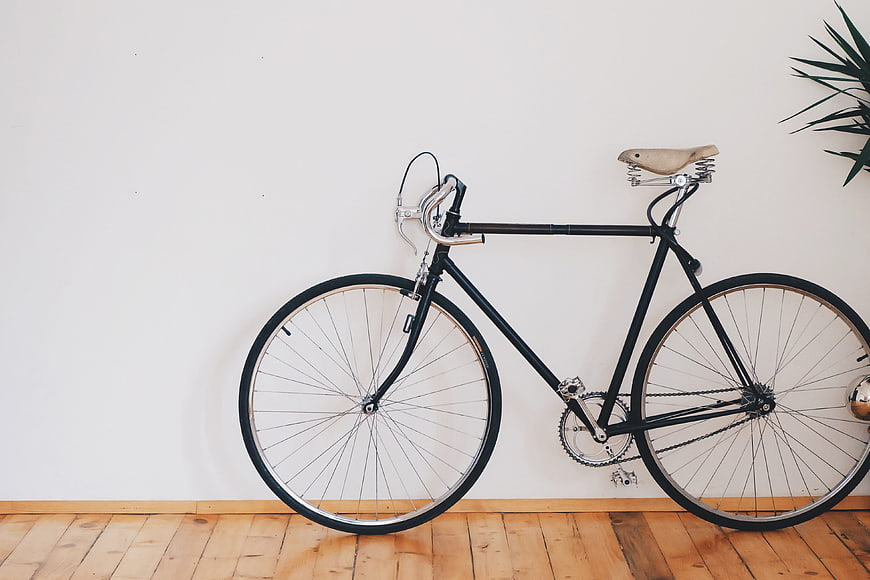 Vintage black bicycle leaning against white wall
