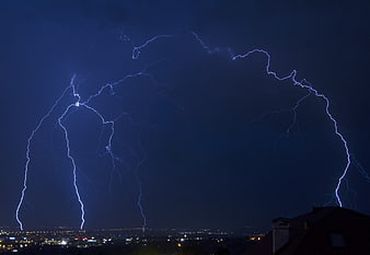 Dramatic Blue Lightning Storm Over City Skyline at Night