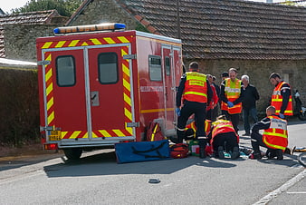 Emergency Medical Team Treating Patient On Roadside Near Fire Truck