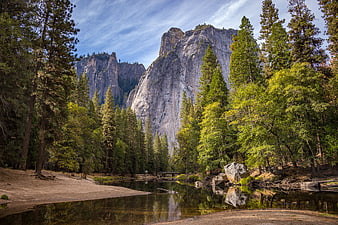Majestic granite cliffs and river in a lush forest landscape