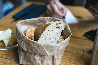 Freshly baked bread slices in paper basket with butter