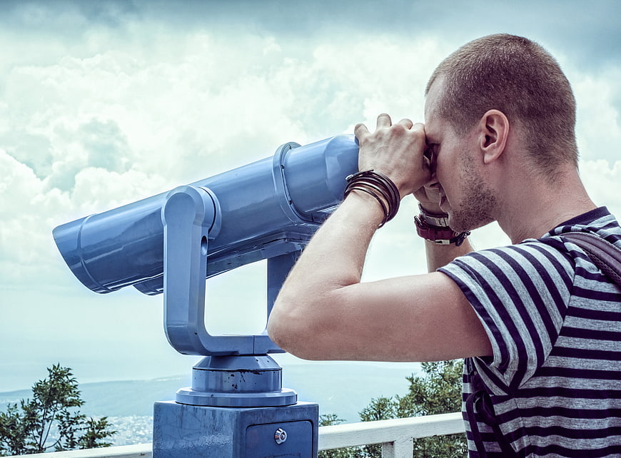 Man Looking Through Coin-Operated Binoculars at Scenic View