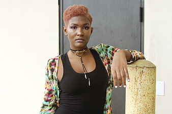 Stylish Woman with Short Orange Hair Leaning on Post