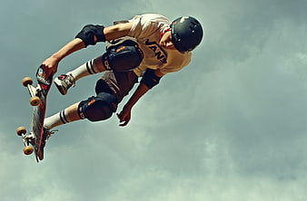 Skateboarder performing aerial trick against cloudy sky