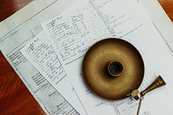 Vintage brass inkwell on antique handwritten ledger papers