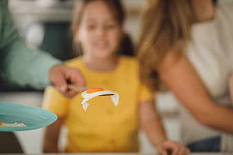 Fried Egg on Fork with Blurred Family Background