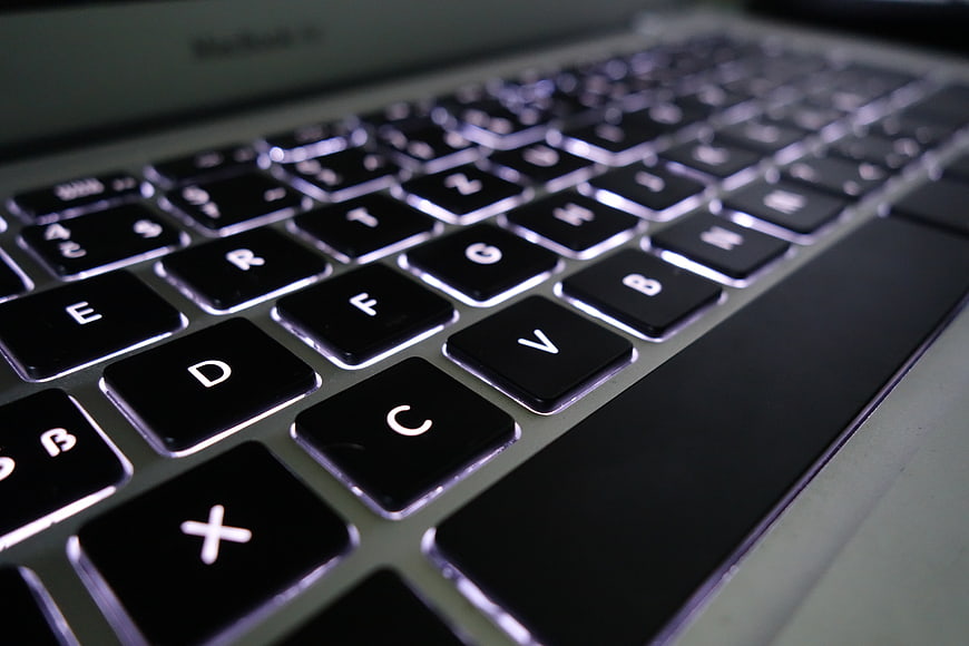 Close-up of a backlit laptop keyboard with shallow depth of field