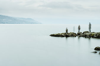 Minimalist Long Exposure Coastline with Blurred Figures on Rocks