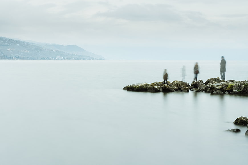 Minimalist Long Exposure Coastline with Blurred Figures on Rocks