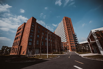 Modern red brick university campus buildings with blue sky