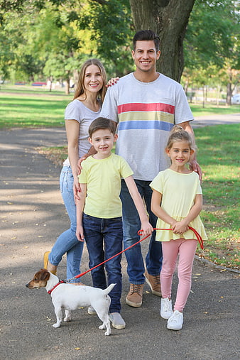 Happy family with dog walking in park