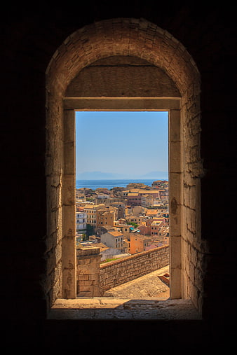 View of Mediterranean town through ancient stone archway