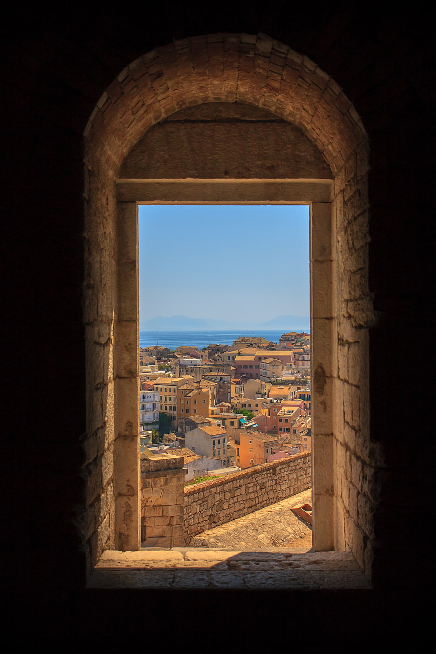 View of Mediterranean town through ancient stone archway