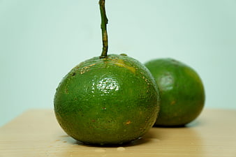 Fresh Green Kumquats on Wooden Board