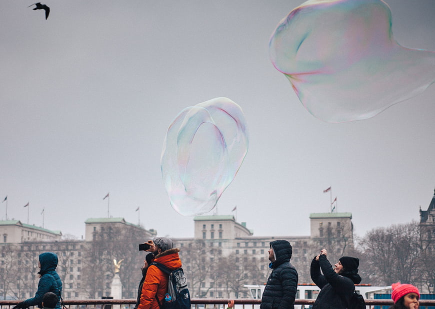 Giant Soap Bubbles Floating Over Cityscape with People