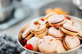 Pink macarons with dried rose petals in a silver bowl