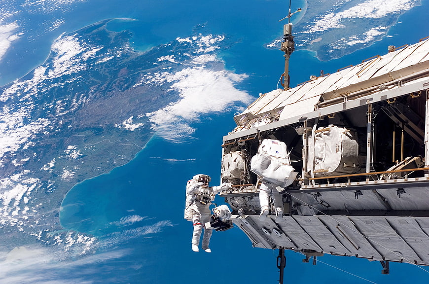 Astronauts performing spacewalk near International Space Station
