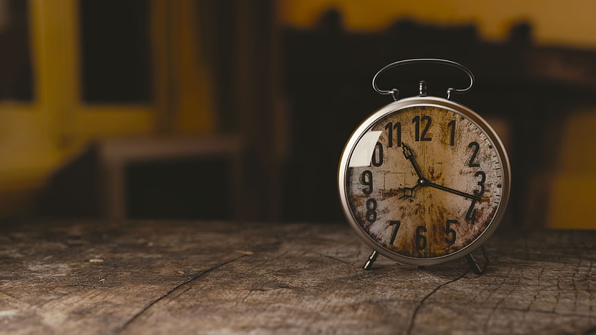 Vintage Rusty Alarm Clock On Weathered Wooden Table