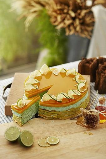 Colorful layered mille crepe cake with lime slices and honey