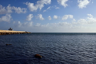 Serene Mediterranean Sea View with Breakwater and Blue Sky