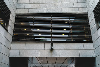 Low angle view of modern building facade with security camera