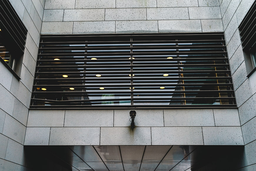 Low angle view of modern building facade with security camera