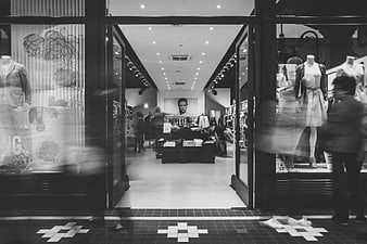 Black and white view of a modern fashion boutique entrance with mannequins