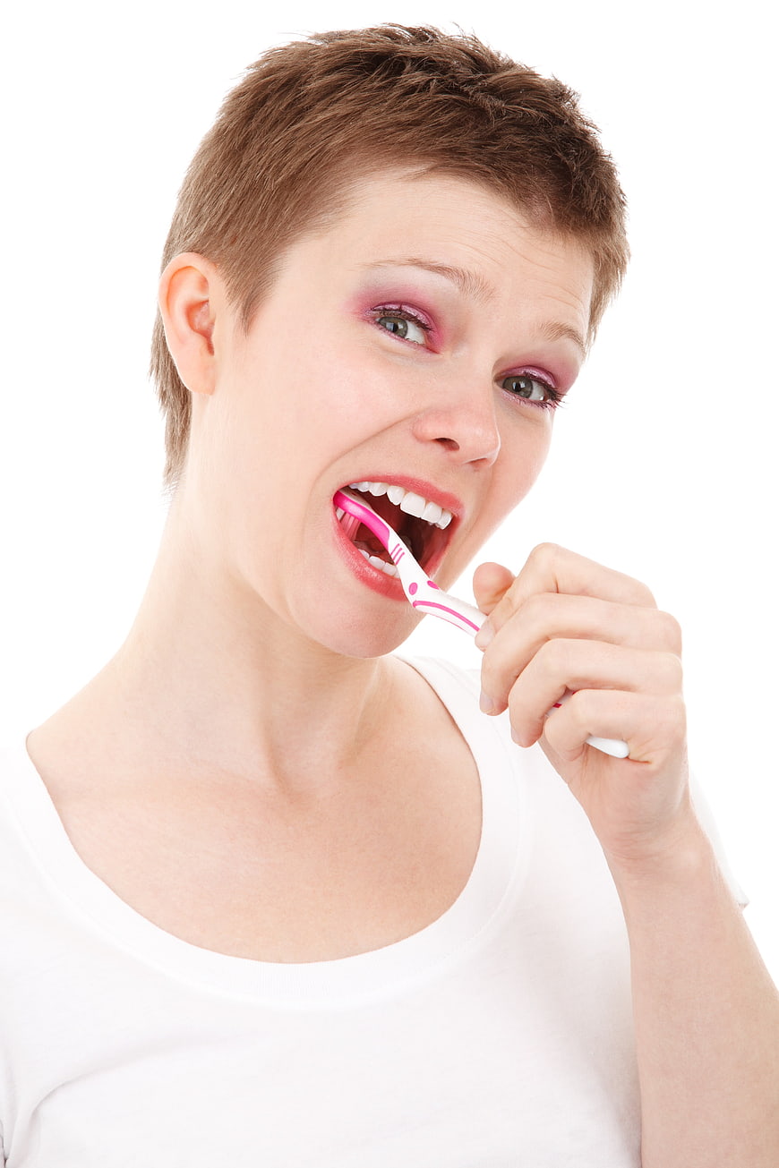 Young Woman Brushing Teeth with Pink Toothbrush