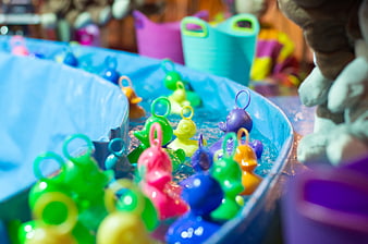 Colorful plastic ducks floating in a blue water basin