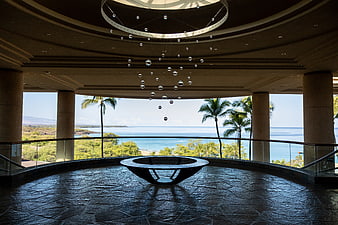 Luxury hotel lobby with ocean view and modern sculpture