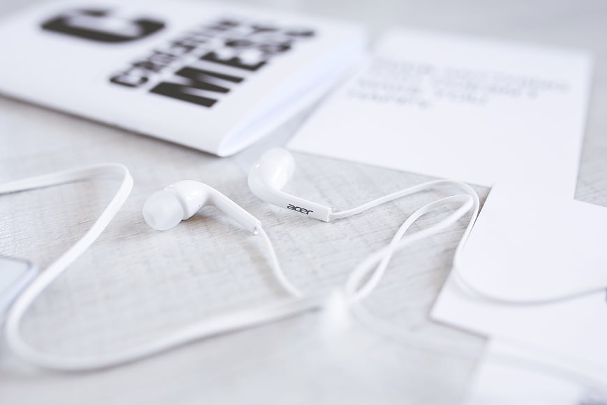 White Acer Earphones on Minimalist Desk with Magazine