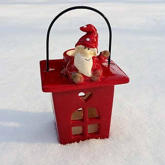 Red ceramic gnome lantern in snow