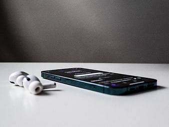 Wireless Earbuds and Smartphone on White Desk