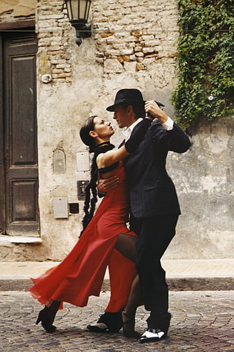 Passionate Tango Dancers in Red Dress and Suit on Cobblestone Street