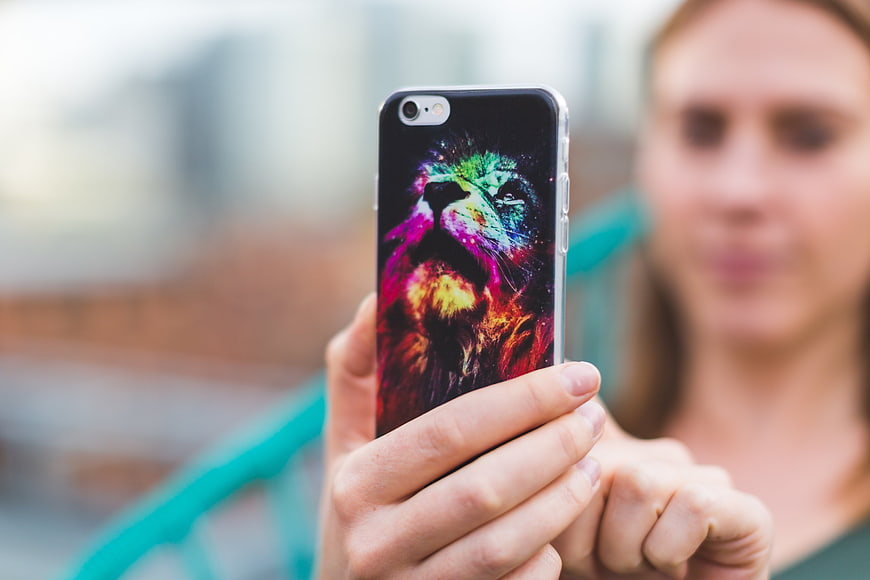 Woman holding smartphone with colorful lion case
