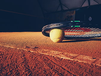 Tennis Racket and Ball on Clay Court