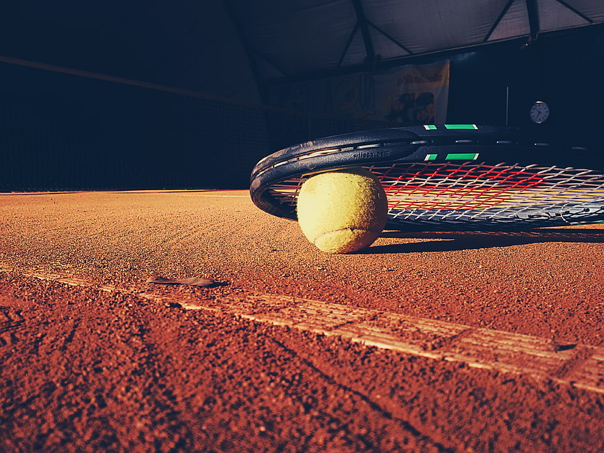 Tennis Racket and Ball on Clay Court