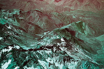 Aerial View of Rugged Mountain Range with Teal and Red Tones