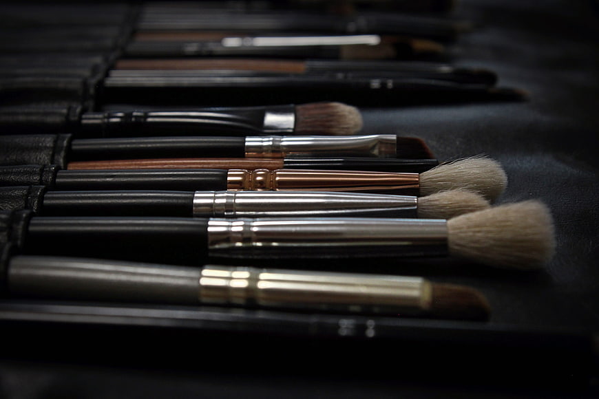 Professional makeup brushes arranged in a black leather case