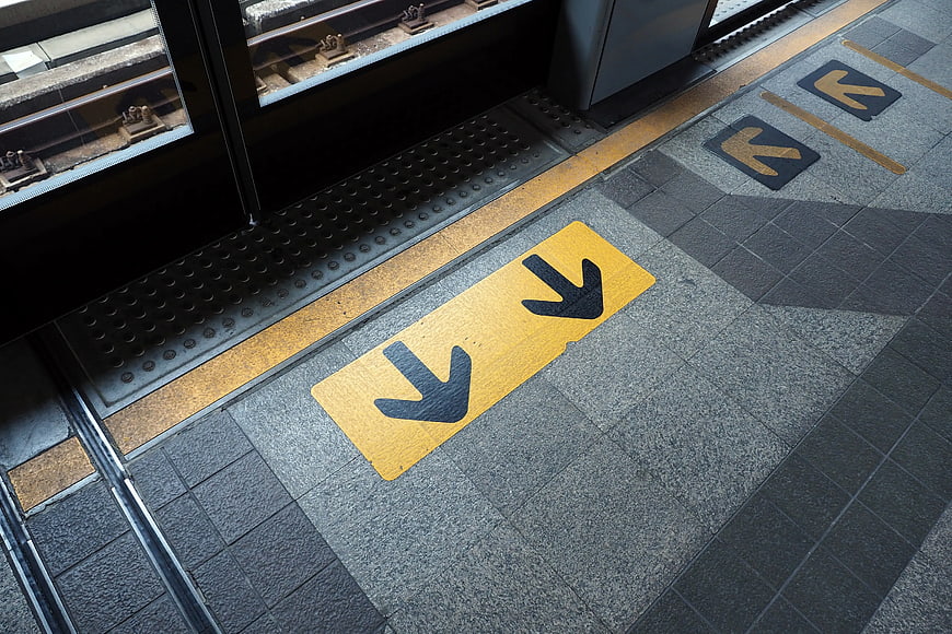 Yellow Directional Arrows on Subway Platform Floor