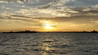 Golden Sunset Over Water with Silhouetted City Skyline