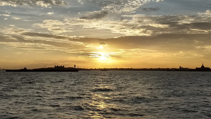Golden Sunset Over Water with Silhouetted City Skyline