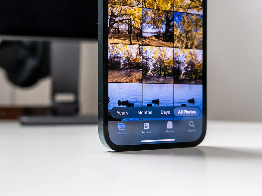 iPhone displaying photo gallery on white desk