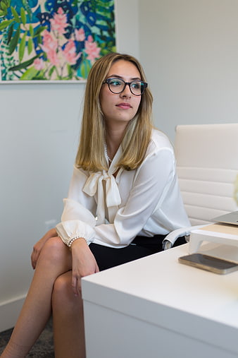 Professional woman with glasses sitting at office desk